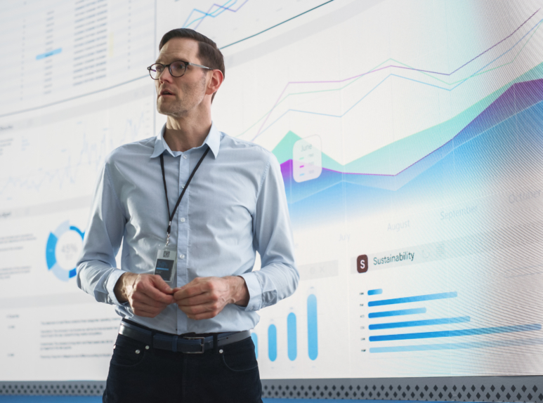 Male CEO Of Data Science Company Is Giving Presentation In Front Of Big Digital Screen With Graphs And Charts. Successful Caucasian Man Reviewing Business Accomplishments And Objectives In the Office. Ceiba Law attorney conducting a virtual legal consultation on computer